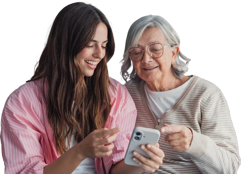 Two women sit together looking at a phone, one showing the other something on the screen